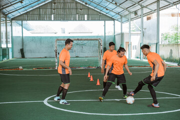 four futsal players practice with the ball