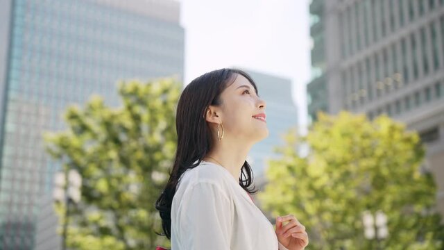 街中で空を見上げる女性