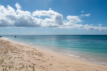Fototapeta na wymiar A view of a white sand beach on the west coast of the island of Barbados in the Caribbean