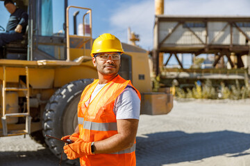 Young worker dressed in safety equipment inside factory