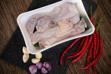 Chicken heads wrapped in polyethylene polymer packaging with chilies