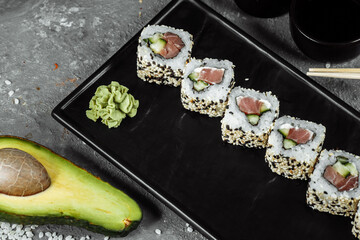 California roll sushi traditional Japanese rice food with salmon, avocado, cucumber, nori and sesame seeds