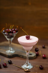 Curd cheese mousse and fresh cherry puree, served in a champagne glass and garnished with cherry berries. Summer desserts concept