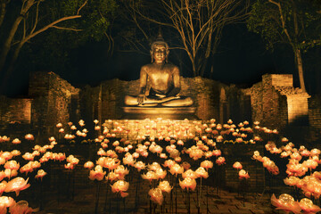 sitting bronze Buddha statue at night with lighting decoration