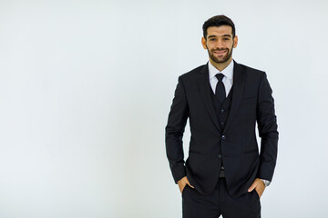Obraz na płótnie Canvas Portrait studio cut out shot of Caucasian success handsome bearded male businessman in formal black suit and necktie standing smiling look at camera holding hands in pants pockets on white background