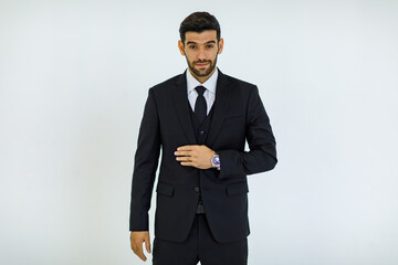 Portrait studio cut out shot of Caucasian success handsome bearded male businessman in formal black suit and necktie standing smiling look at camera holding hands in pants pockets on white background
