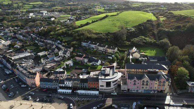 Bantry, County Cork Ireland. Aerial view of buildings by bay and green landscape on sunny day, establishing drone shot