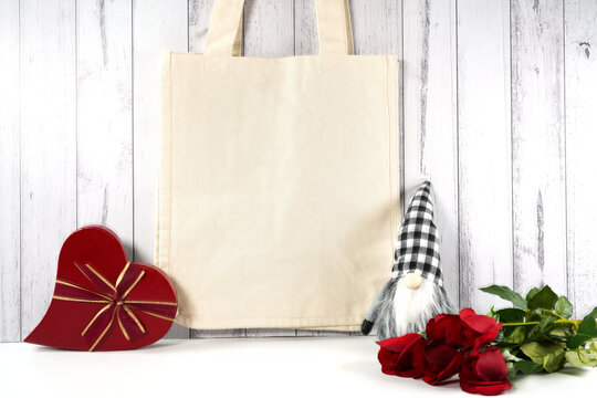 Tote Bag product mockup. Valentine's Day farmhouse theme SVG craft product mockup styled with red roses, heart shaped gift, and buffalo plaid gnome against a white wood background.