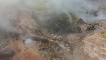 A geyser erupts on a mountainside. The water in the boiler is boiling. Hot steam envelops...