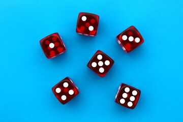 Six red dice lie on an isolated blue background.