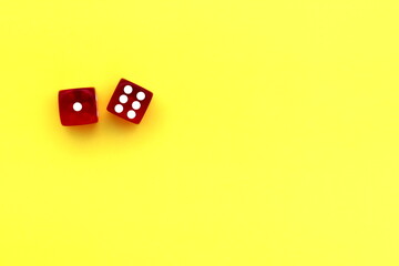 Two red dice lie on a yellow background with space for text.