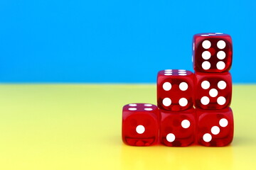 A pyramid of six dice for the game stands on yellow and blue.