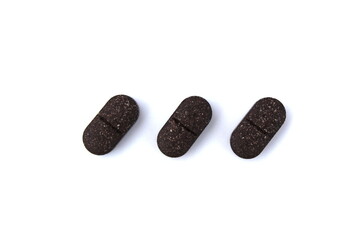 Three oblong tablets lie on a white isolated background.