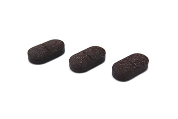  Three oblong tablets lie on a white isolated background.