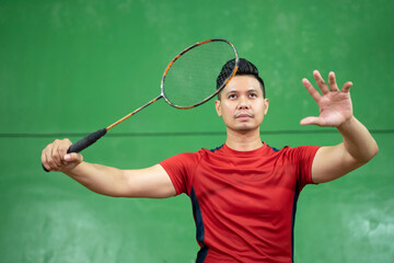 Asian male badminton player ready to receive the shuttlecock