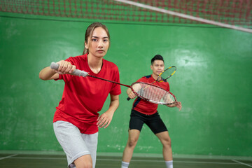 Beautiful badminton player looking at camera with a ready stance