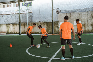 some futsal players practice dribbling past other players