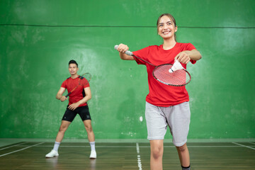 Female badminton players serving when starting to play badminton