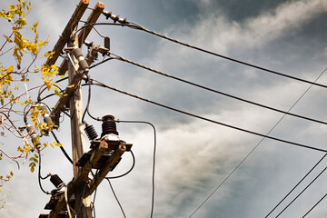 High-voltage electric cable poles, gold, blue-orange, like it's about to rain.