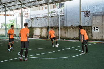 four futsal players practice passing the ball