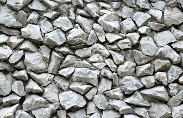 Crushed grey stone or rock wall gravel abstract patterns background texture.