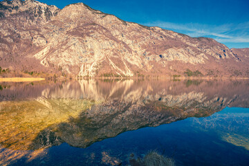 Mountain lake with beautiful reflection. Lake Bohinj in early spring. Triglav national park, Slovenia