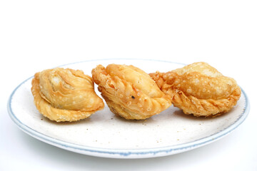 Close up brown Deep fried curry puff on white plate isolated on white