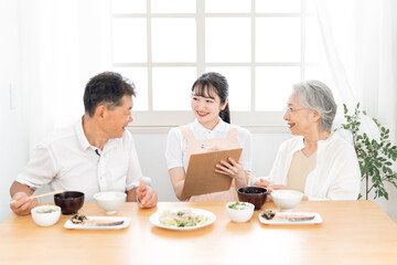 高齢者の食事をチェックする女性（栄養士）
