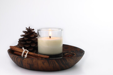burning luxury aromatic scented candle glass on the white table with dried plants and spices with background of white cement wall in the bedroom to creat relax and romantic ambient on Valentine day