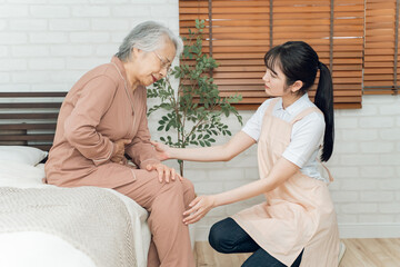 痛がる高齢者女性と介護士の女性（腹痛）