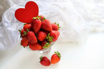 original postcard happy valentine's day. ripe strawberries and red heart on a white background. space for text