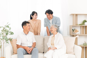 Fototapeta premium ソファに座って飲み物を飲む家族（話す） 