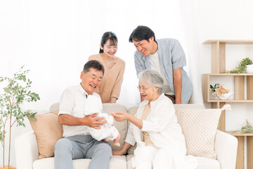 Fototapeta premium 赤ちゃんを抱いた老夫婦と若い夫婦（里帰り） 