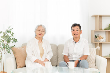 ソファに座る高齢者夫婦（お茶）
