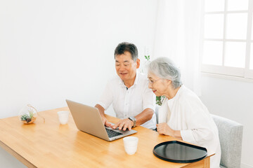 ノートパソコンを使う高齢者夫婦
