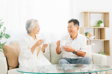ソファに座る高齢者夫婦（お茶）
