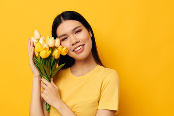 Portrait Asian beautiful young woman in a yellow t-shirt t-shirt with a bouquet of flowers holiday Lifestyle unaltered