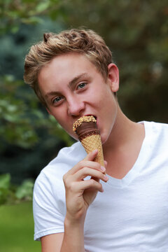 Teenage Boy Eating A Frozen Treat Ice Cream Cone With Nuts