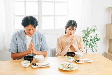 食事をする若い夫婦（いただきます）

