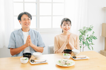 Obraz na płótnie Canvas 食事をする若い夫婦（いただきます） 
