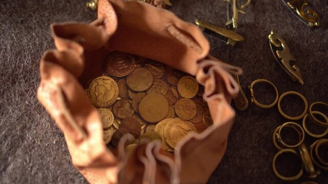 Medieval authentic leather wallet bag with gold coins. Historical jewelry. Money, ring, gold brooch and jewelry