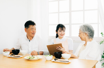 高齢者の食事をチェックする女性（栄養士）

