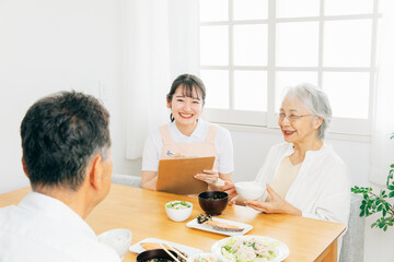 高齢者の食事をチェックする女性（栄養士）
