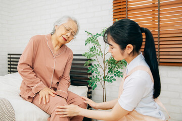 痛がる高齢者女性と介護士（膝痛）