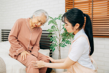 痛がる高齢者女性と介護士（膝痛）
