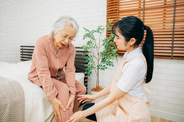 痛がる高齢者女性と介護士（足首）