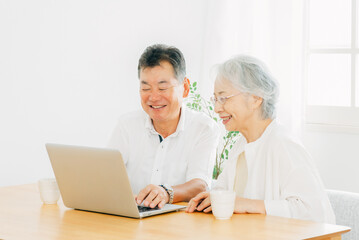 Fototapeta na wymiar ノートパソコンを見る高齢者夫婦（笑顔） 