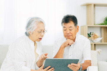 Obraz premium タブレットPCを見る高齢者夫婦（困る） 