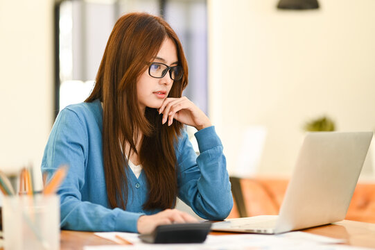 Young businesswoman wearing glasses working in the office with a laptop.