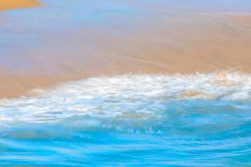 Abstract blurred patterns of a Pacific ocean wave at the beach in a famous tourist destination, Seal Beach in California, USA, long exposure